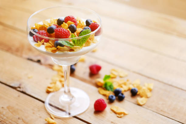 istock Crunchy corn flakes with some wild berries in a glass cup. 901484422