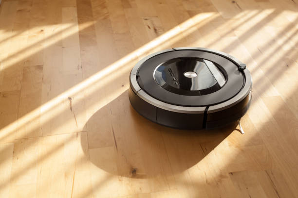 robotic vacuum cleaner on laminate wood floor smart cleaning technology stock photo