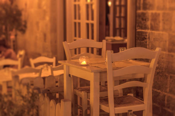 Dinner for two on a sunset background.Greece, Santorini, restaurant on the beach, above the volcano