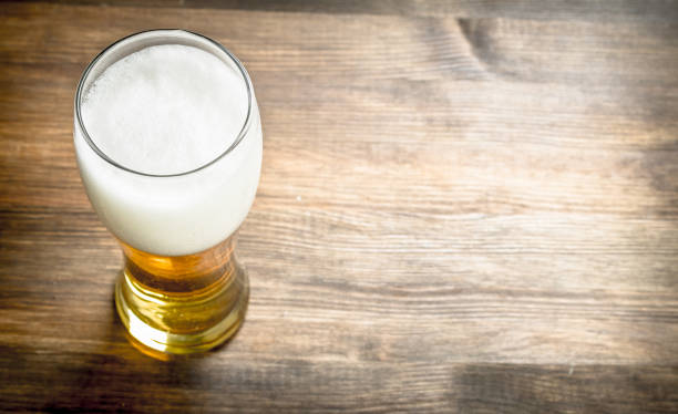 istock mug of fresh beer. On wooden table. 901488584