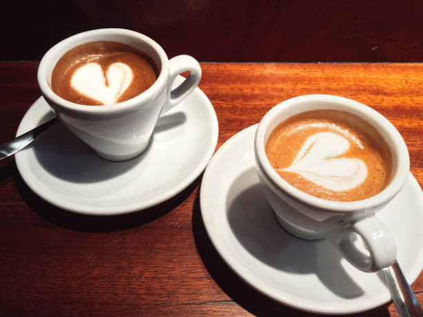 Two espresso cups, cosily close to each other, with a \