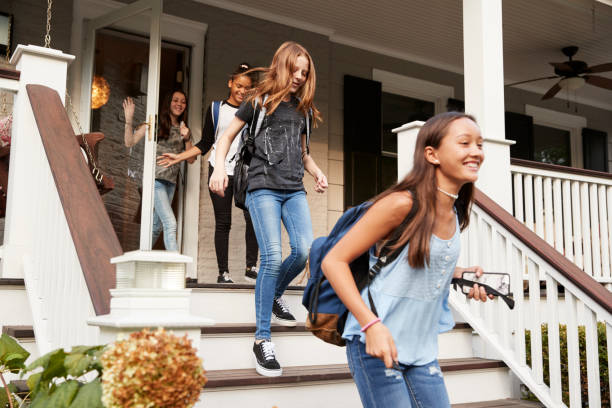 Four teen girls leaving house with school bags Four teen girls leaving house with school bags only girls stock pictures, royalty-free photos & images