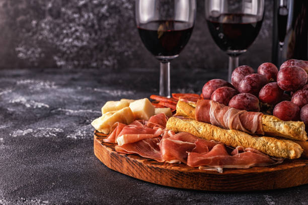 istock Prosciutto, sausage, wine, grape, parmesan on dark table 901492842