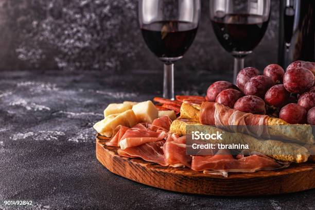 Prosciutto Sausage Wine Grape Parmesan On Dark Table Stock Photo - Download Image Now