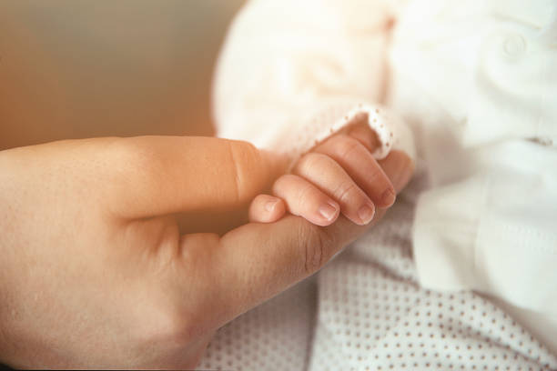 istock Newborn Baby Holding Mothers Hand 901493112