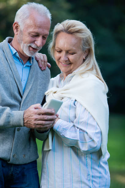 istock Happy senior couple using a phone, outdoors 901493292