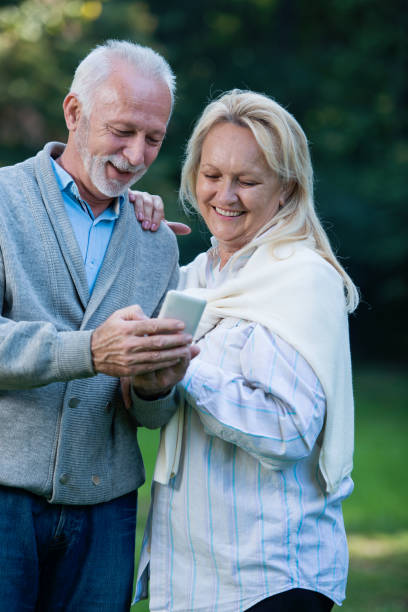 istock Happy senior couple using a phone, outdoors 901493400