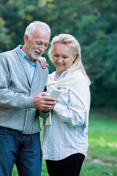 istock Happy senior couple using a phone, outdoors 901493426