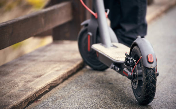 scooter électrique se tient sur un pont dans la rue. - tricycle photos et images de collection