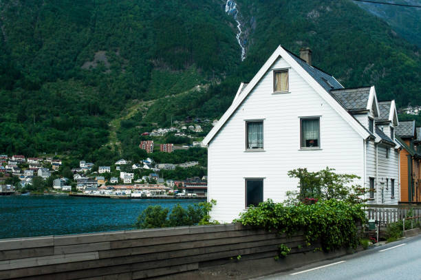Omastranda, Norway - July 23, 2008: Hardangerfjord in south western Norway in the summer. A red, Norwegian house situated on a small island in the fjord. In the distance the Folgefonna glacier. Othing happens; all is quiet.