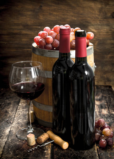 istock Wine background. A barrel with red wine and freshly grapes. 901500664