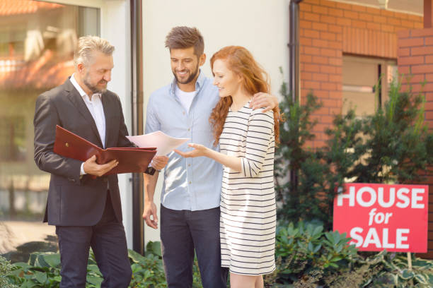 Apartment seller presenting buying conditions Seller of apartment presenting conditions for buying property to smiling couple estate worker stock pictures, royalty-free photos & images