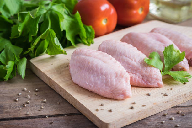 istock Raw chicken wings on wooden cutting board 901509122
