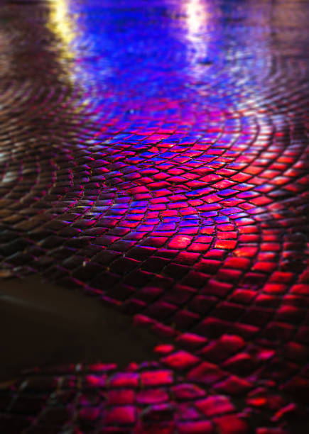 Abstract urban background. Streets after rain withreflections of light on wet roadway. Pavement textureAbstract urban background. Streets after rain with reflections of light on wet roadway. Pavement texture