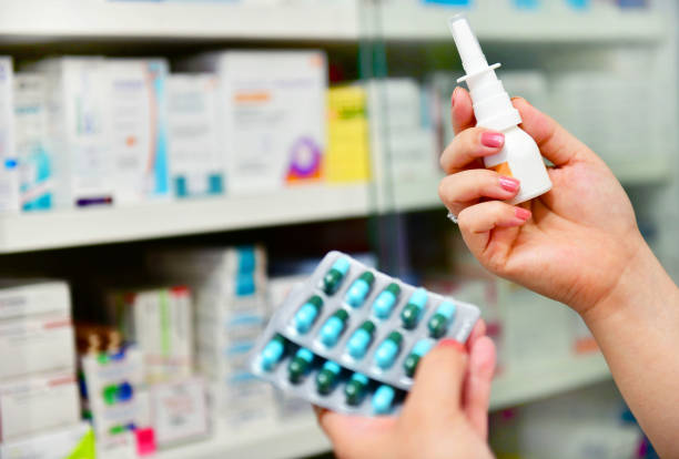 pharmacist holding nasal spray medicine and capsule pack stock photo
