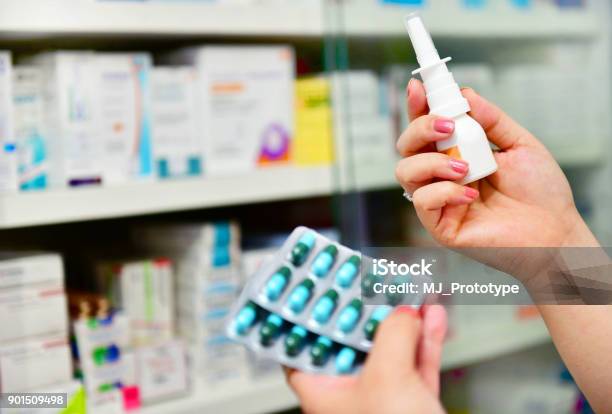 Pharmacist Holding Nasal Spray Medicine And Capsule Pack Stock Photo - Download Image Now