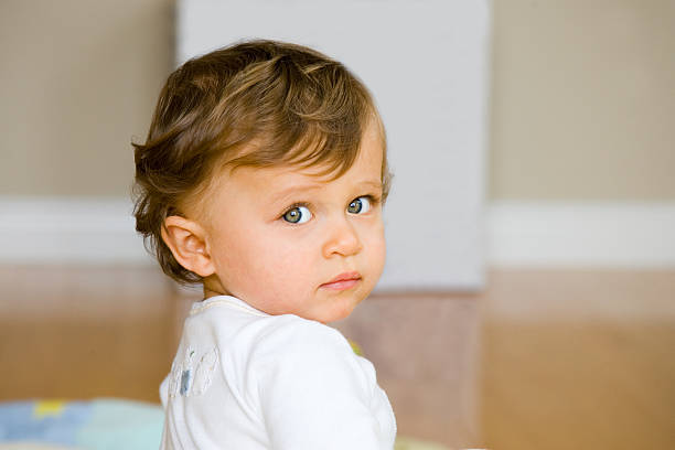 People - Portrait of baby girl looking over her shoulder stock photo