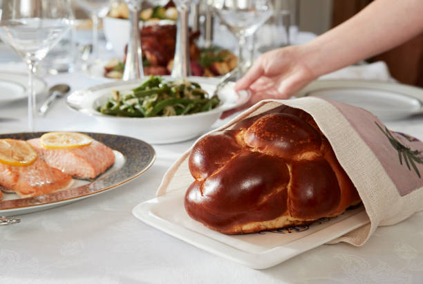 hand placing dish on table set for jewish shabbat, close up - passover judaism seder seder plate imagens e fotografias de stock