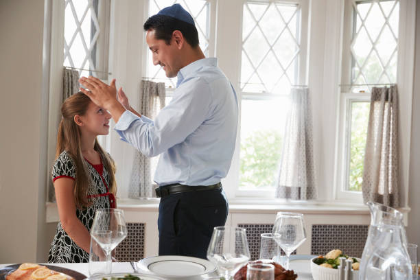 jüdischen vater segnet tochter von tisch für shabbat mahlzeit - seder passover judaism family stock-fotos und bilder