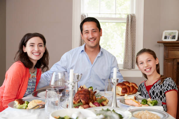 famille juive à shabbat dîner table souriant à la caméra - seder passover judaism family photos et images de collection