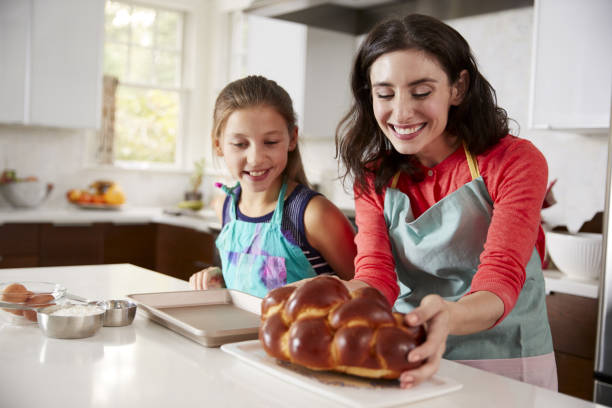 mère et fille dans la cuisine avec le challa fraîchement sorti du four - judaism photos et images de collection