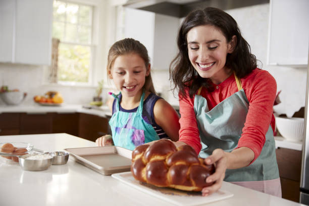 Mother and daughter in kitchen with freshly baked challah Mother and daughter in kitchen with freshly baked challah judaism photos stock pictures, royalty-free photos & images