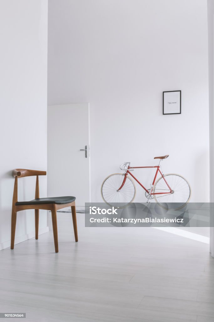 Classic chair in bright hall Classic chair in bright hall with red bike against wall with picture next to door Domestic Life Stock Photo