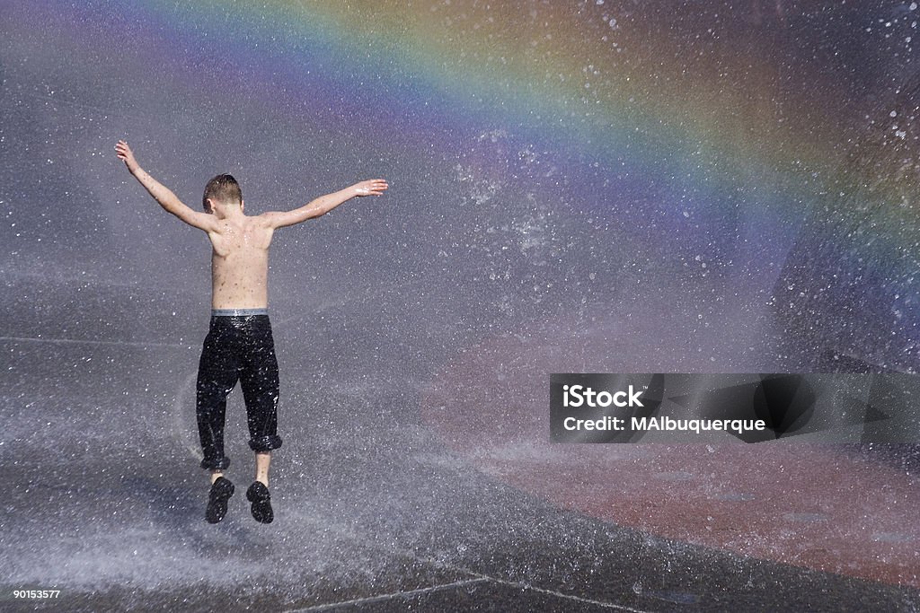 Child's Hot Summer Joy Under the Rainbow  Dancing Stock Photo