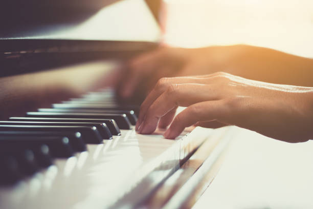 primo piano della mano di una donna felice che suona il pianoforte al mattino. - music lessons foto e immagini stock