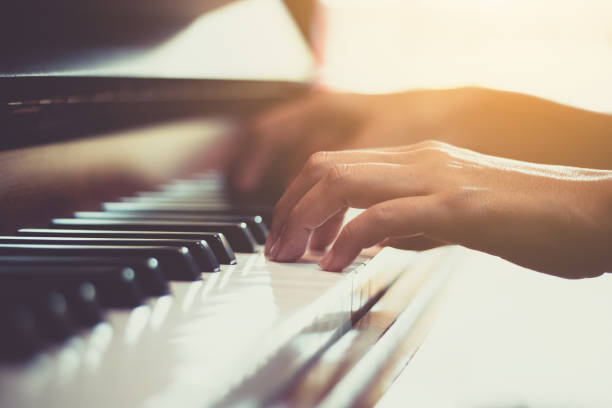 feche-se da mão da mulher feliz jogando o piano pela manhã. - piano - fotografias e filmes do acervo