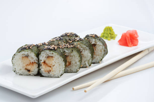 istock sushi or rolls on a long plate, wooden sticks, red ginger and wasabi 901539652