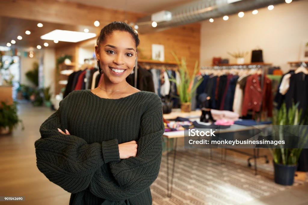 Young Hispanic woman smiling to camera in a clothes shop Retail Clerk Stock Photo