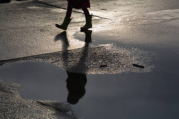 istock child with top boots on walking through a puddle 90154306