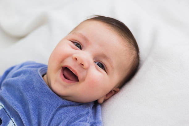 close up of smiling baby lying in his crib stock photo