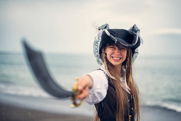 Happy , stong and confident pirate girl holding a sabre. \n
