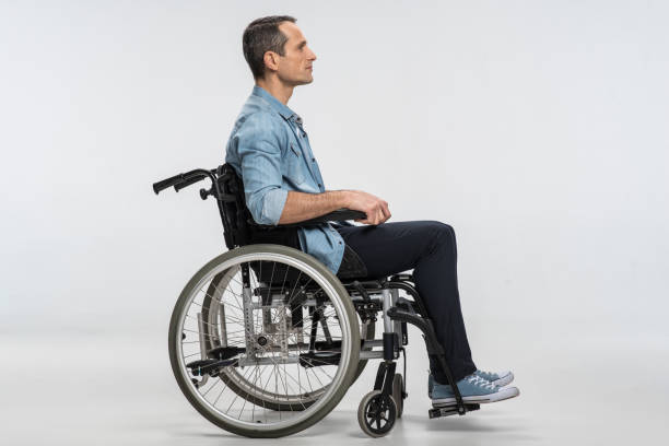bon homme paralysé au repos en wheelchai - physical injury men orthopedic equipment isolated on white photos et images de collection