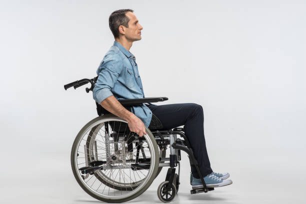 beau physiquement handicapé homme se déplaçant en fauteuil roulant - physical injury men orthopedic equipment isolated on white photos et images de collection