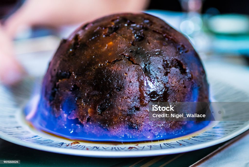 Christmas pudding on fire Christmas pudding being set of fire with brandy as a tradition Christmas Pudding Stock Photo