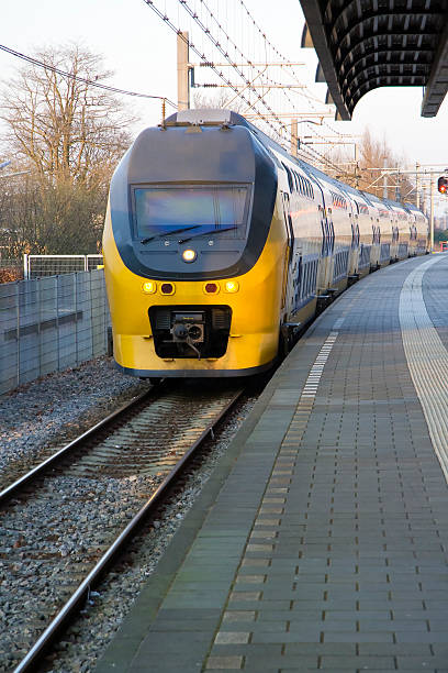 train arriving at station - trein nederland stockfoto's en -beelden