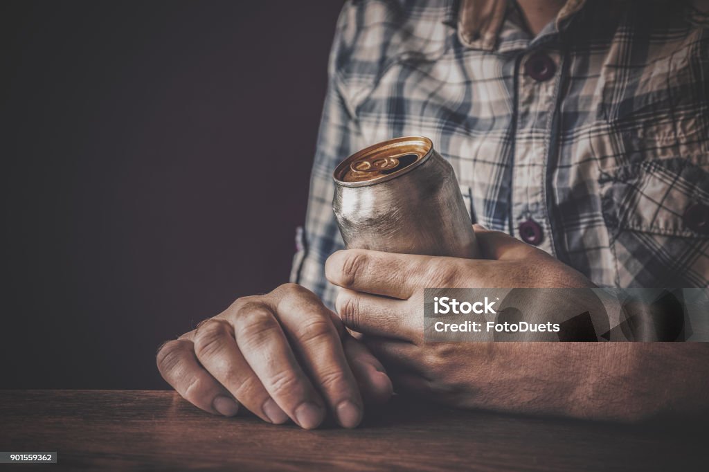 Homme de boire une bière bien fraîche après le travail dans la soirée. Main tenant une canette en aluminium. Temps de repos dans le bar ou le pub. Atmosphère sombre de dépressif. Concept de problème d’alcool. - Photo de Alcoolisme libre de droits