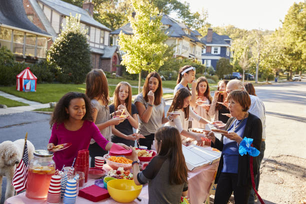 vecinos se a comida en una fiesta de bloque - fiesta callejera fotografías e imágenes de stock