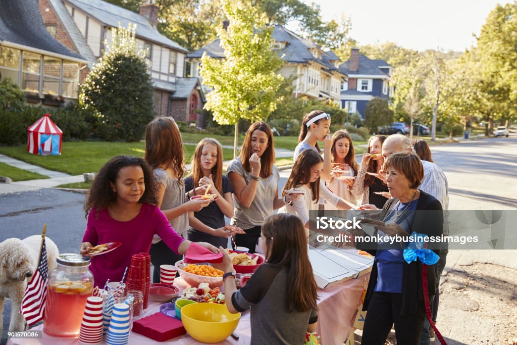 Neighbours helping themselves to food at a block party Community Stock Photo