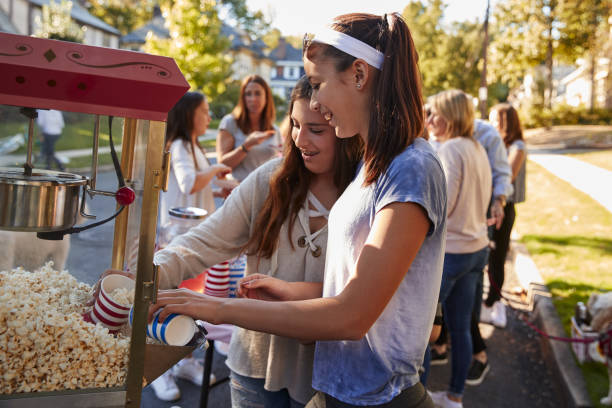 chicas sirven palomitas de maíz en el partido de bloque de barrio - fiesta callejera fotografías e imágenes de stock