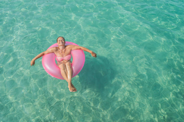 istock Senior woman enjoy sea water 901570856