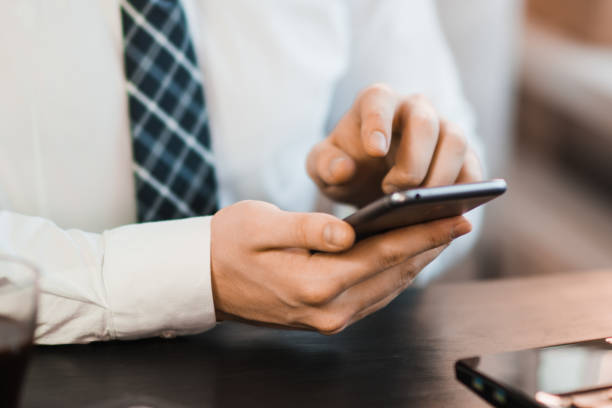 istock Male hands using smartphone with abstract financial charts and map over office desktop 901571114