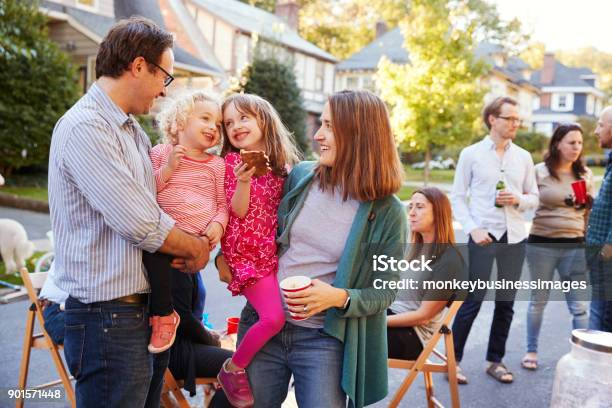 Genitori Che Tengono I Loro Figli Piccoli Mentre Mangiano A Una Festa Di Blocco - Fotografie stock e altre immagini di Vicino di casa