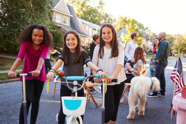tres niñas adolescentes en scooter y una moto en un bloque de partido - fiesta callejera fotografías e imágenes de stock