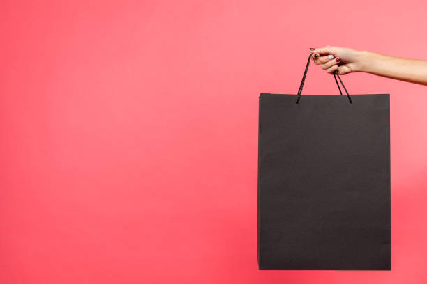 istock woman holding black shopping bag 901571470