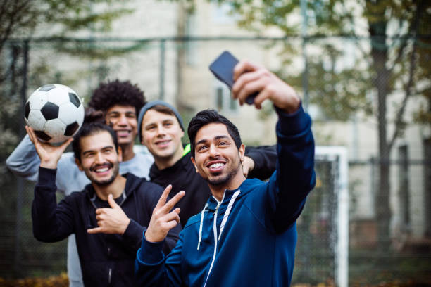 lächelnd spieler nahmen selfie über mobiltelefon - soccer player soccer men smiling stock-fotos und bilder