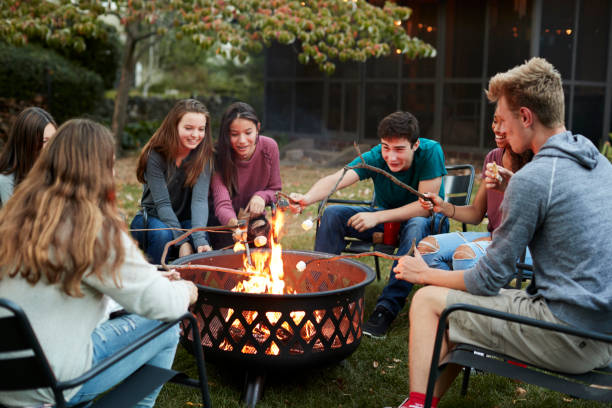 istock Teenage friends sit round a fire pit toasting marshmallows 901571972
